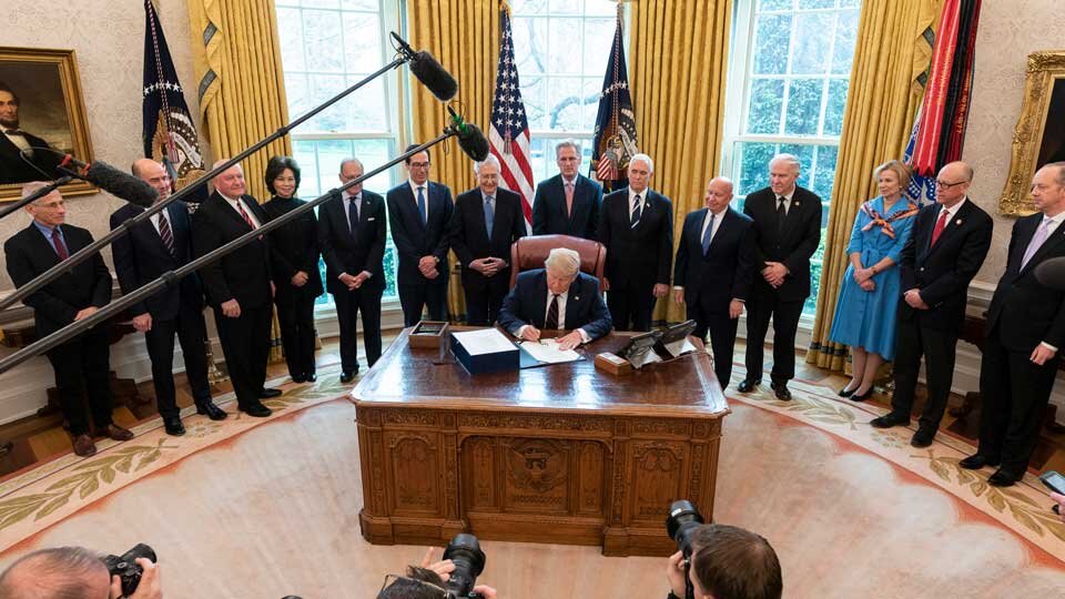 President Trump signing the CARES Act on Friday. Photo Credit: AP Images